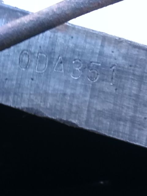 1992 Ford Bronco - Close-up of a metal plate showing stamped characters '0DA351' and a partial diagonal bar.