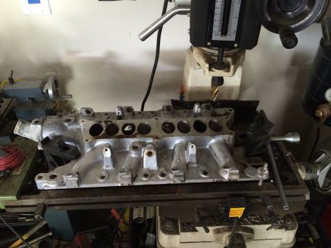 1996 Ford Bronco - An aluminum intake manifold is positioned on a milling machine, ready for modification.