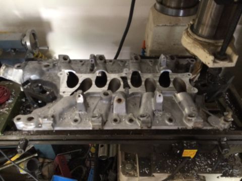 1996 Ford Bronco - Intake manifold on a milling machine, likely undergoing modification or repair.