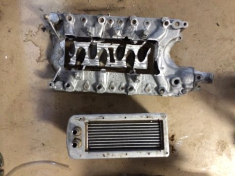 1996 Ford Bronco - Engine parts, including a supercharger manifold and intercooler, are laid out on a concrete surface.