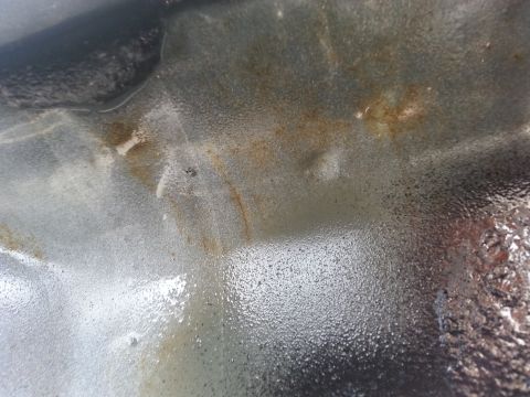 1992 Ford Bronco - This image shows a corroded metal surface with visible rust and a textured finish, along with website text.