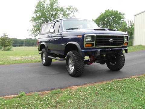 1982 Ford Bronco - This lifted blue Ford Bronco features a soft top and a distinctive 1980s body style, differing from the registry's 1982 claim.