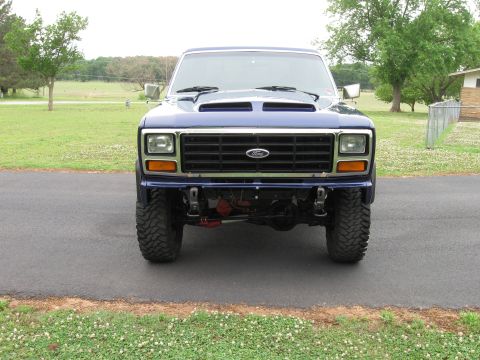 1982 Ford Bronco - Front view of a blue Ford pickup truck with a custom hood scoop and bumper.
