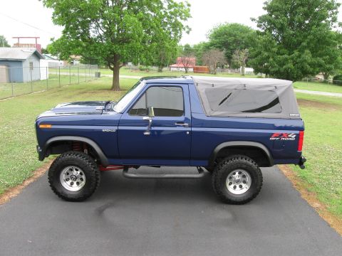 1982 Ford Bronco - This lifted blue Ford Bronco has a soft top and off-road tires.