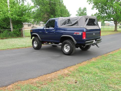 1982 Ford Bronco - This lifted 1982 Ford Bronco features a blue exterior and a removable soft top, ready for off-road adventures.