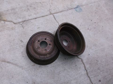 1979 Ford Ranchero - Pair of used brake drums resting on cracked concrete. No vehicle visible.