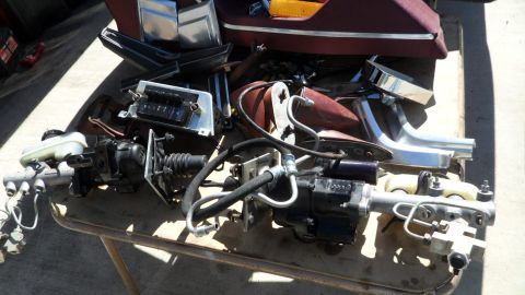 1972 Ford Ranchero - A collection of automotive parts, including a brake booster and master cylinder, are laid out on a table.