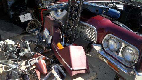 1972 Ford Ranchero - Front view of a 1972 Ford Ranchero with various car parts scattered around it.