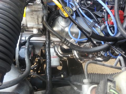 1994 Ford Bronco - Close-up view of engine components including exhaust headers and oil filter.
