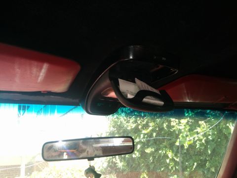1988 Ford Bronco - The overhead console of a vehicle features a sunglasses holder and a digital display showing the temperature.