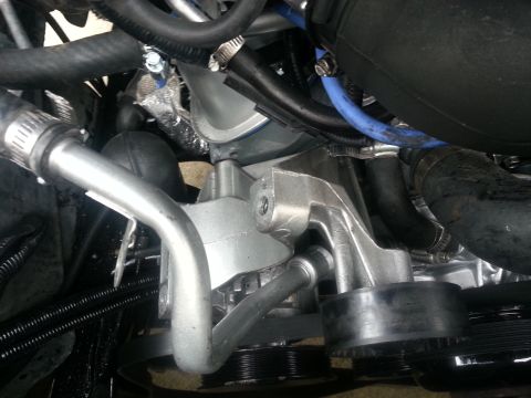 1994 Ford Bronco - Close-up view of an engine component with various hoses and pulleys attached.