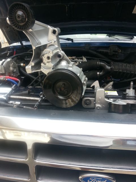 1994 Ford Bronco - The engine bay of a truck is open, with various engine components laid out on the front grille.