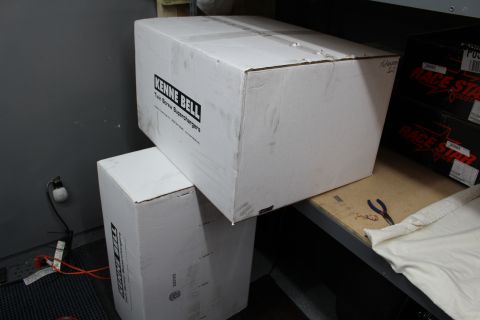 2003 Ford Crown Victoria - white Kenne Bell labeled box on a garage shelf beside stacked Race Star boxes and a draped surface.