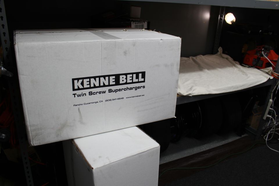Kenne Bell Twin Screw Superchargers box on shelf with tires and chainsaw