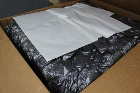 2003 Ford Crown Victoria - White paper sheets resting atop crumpled dark plastic packing material inside a cardboard shipping box.