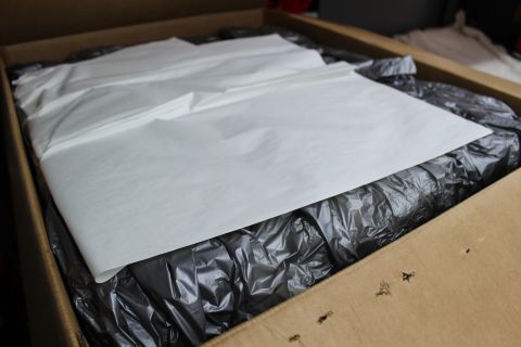 2003 Ford Crown Victoria - Folded white paper laid over crumpled black plastic packing within an open brown cardboard box.
