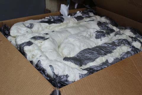 2003 Ford Crown Victoria - cardboard box packed with white packing foam and embedded streaks of dark plastic wrap.