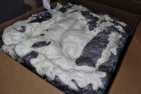 2003 Ford Crown Victoria - Open cardboard box brimming with ridged white packing foam interlaced with dark plastic wrap.