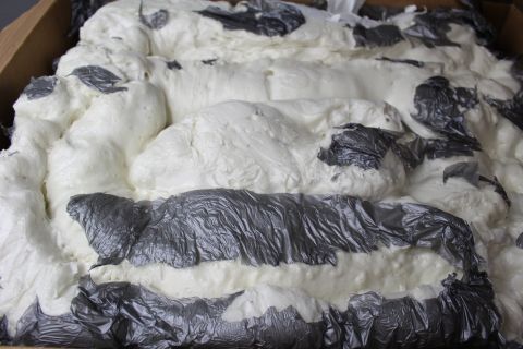 2003 Ford Crown Victoria - Tight close-up of white packing foam ridges with pressed-in strips of gray plastic film.