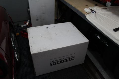 2003 Ford Crown Victoria - white Kenne Bell Twin Screw Supercharger box sits on a shop floor next to a red car's front wheel.