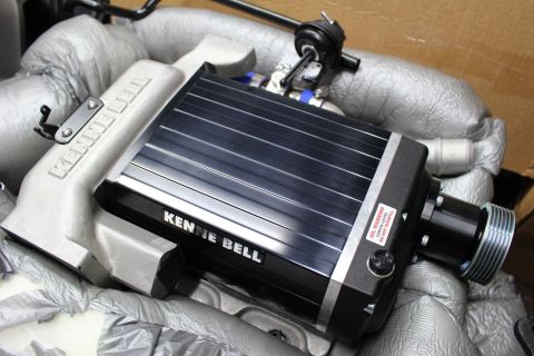 2003 Ford Crown Victoria - Close-up of a Kenne Bell supercharger showing its black finned lid, aluminum casing and grooved drive pulley snout.