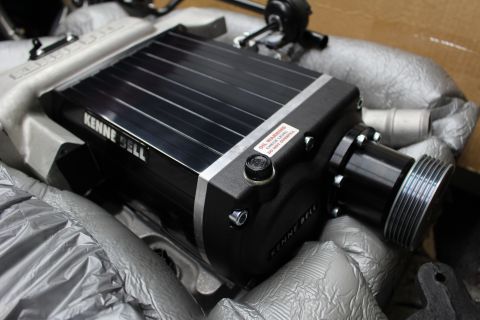 2003 Ford Crown Victoria - angled view of a Kenne Bell supercharger highlighting the grooved drive pulley, oil-fill cap and red warning sticker.