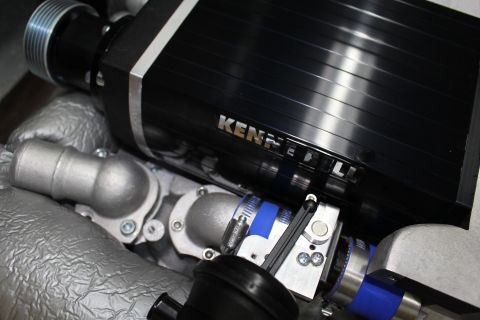 2003 Ford Crown Victoria - Close-up of a Kenne Bell supercharger showing blue silicone hoses, a bypass valve and aluminum coolant fittings.