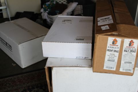 2003 Ford Crown Victoria - Several cardboard shipping boxes are stacked indoors, including Racemaster M&H Front Drag tire boxes and a Kenne Bell box.