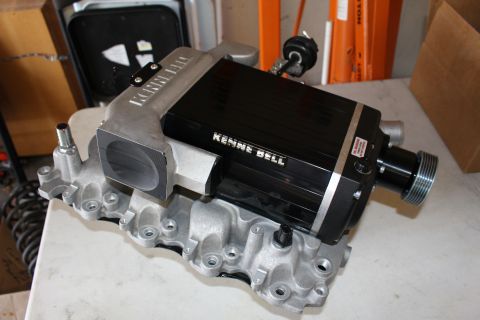 2003 Ford Crown Victoria - Kenne Bell supercharger mounted on a cast aluminum intake manifold rests on a white workbench in a garage.