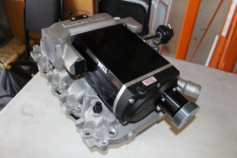 2003 Ford Crown Victoria - Kenne Bell supercharger assembly with grooved drive pulley sits on a workbench in front of a folding chair.