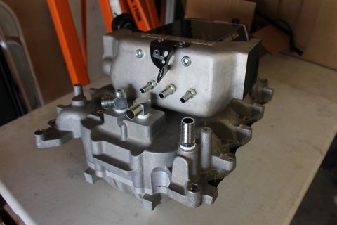 2003 Ford Crown Victoria - Bottom view of a Kenne Bell cast aluminum intake manifold showing port openings, studs and nipple fittings on a bench.