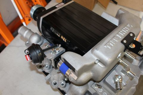 2003 Ford Crown Victoria - black Kenne Bell supercharger mounted on an aluminum manifold, fitted with a blue silicone coupler, clamps and a round boost actuator.