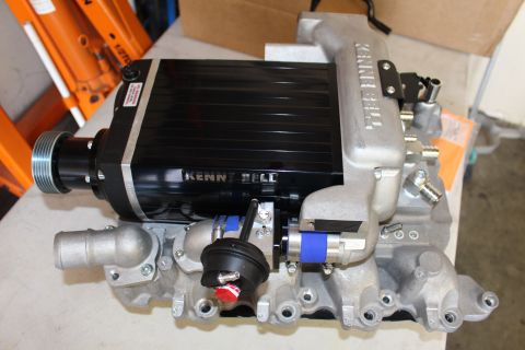 2003 Ford Crown Victoria - black Kenne Bell supercharger on a cast-aluminum manifold, fitted with snout pulley, blue coupler and a red-tagged boost actuator.
