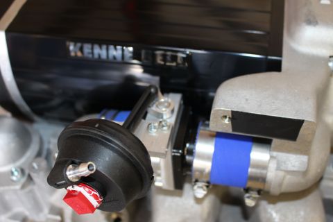 2003 Ford Crown Victoria - close view of a black round bypass actuator with a red warning tag beside a blue silicone coupler under the Kenne Bell name.