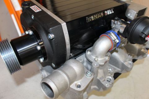 2003 Ford Crown Victoria - black finned Kenne Bell supercharger with snout pulley sits on a cast-aluminum manifold with a curved inlet elbow and blue coupler.