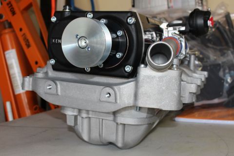 2003 Ford Crown Victoria - front view of a supercharger showing a polished pulley on a black bolted gear case atop a ribbed cast-aluminum manifold.