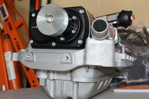 2003 Ford Crown Victoria - supercharger front end with a polished pulley and black housing seated on a ribbed cast-aluminum manifold with an inlet snout.