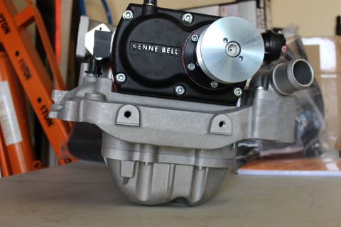 2003 Ford Crown Victoria - black Kenne Bell gear case with a polished pulley mounted on a ribbed cast-aluminum intake manifold against a shop background.