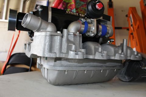2003 Ford Crown Victoria - Front-angle view of a Kenne Bell supercharger mounted on a long ribbed aluminum intake manifold in a garage.