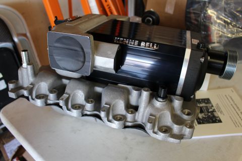 2003 Ford Crown Victoria - Low-angle three-quarter view of a Kenne Bell supercharger and its throttle inlet mounted on a long aluminum intake manifold.