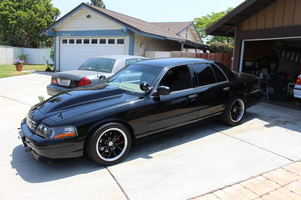 Front three-quarter of a black Ford Crown Victoria with cowl hood