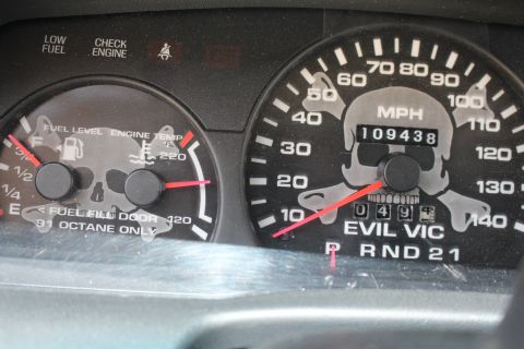 2003 Ford Crown Victoria - custom gauge cluster with skull graphics reads EVIL VIC, showing 109,438 miles and a 91-octane-only fuel note.