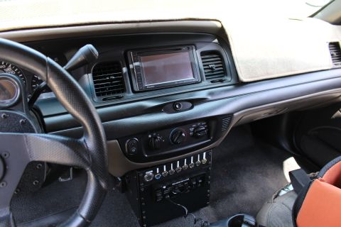 2003 Ford Crown Victoria - Vehicle dashboard with a Pioneer double-DIN touchscreen, climate controls, and a custom row of toggle switches mounted below.