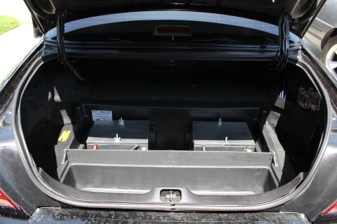 2003 Ford Crown Victoria - Open sedan trunk containing a fabricated black-and-metal equipment rack spanning the trunk well.