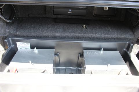 2003 Ford Crown Victoria - Close-up of a Police Trunk Pack metal equipment tray in a trunk, with an Alpine component mounted on the carpet above it.