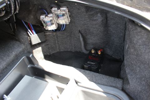 2003 Ford Crown Victoria - Carpeted trunk corner fitted with clear audio capacitors on the wall and an XS Power Batcap auxiliary battery on the floor.