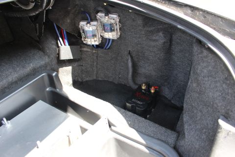 2003 Ford Crown Victoria - Sedan trunk interior with two clear audio capacitors, wiring, and a black Batcap auxiliary battery in the carpeted corner.