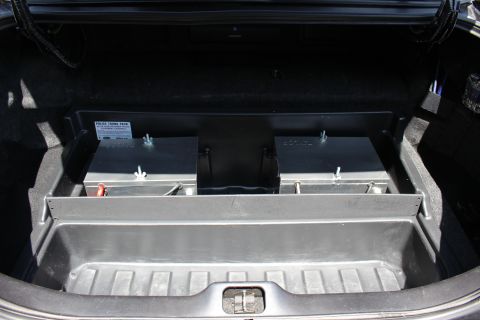 2003 Ford Crown Victoria - Sedan trunk fitted with a Police Trunk Pack tray that holds two large metal battery boxes with red and black terminals.