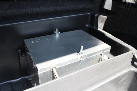 2003 Ford Crown Victoria - bare-metal equipment box fastened with wing nuts and straps inside a black plastic trunk tray.