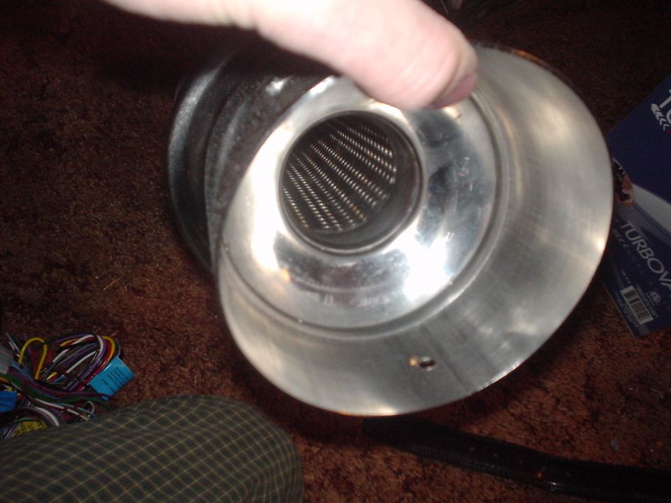 Polished aluminum air intake cone with mesh screen held in hand beside wiring harness